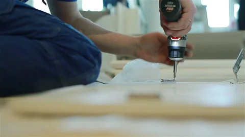 Construction worker screwing a screw into a wooden board. Close up Stock Footage 48136539