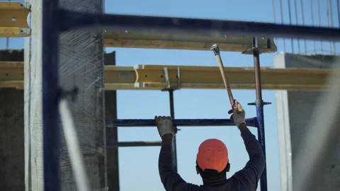 Construction worker securing formwork with hammers on site Stock Footage 318411602