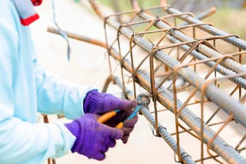 Construction worker securing steel bars with wire rod. Foto stock