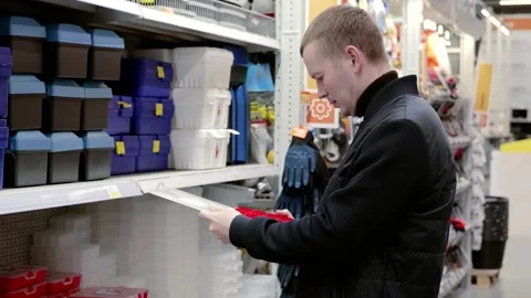 Construction worker selecting a red toolbox in a hardware store. Holding the Stock Footage 311463008