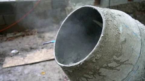 Construction worker shoveling cement into a cement mixer Stock Footage 158972894