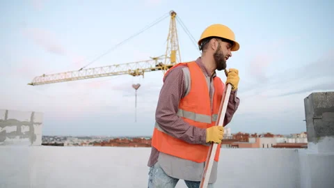 Construction worker sings using measures level at building site Stock Footage 295960841