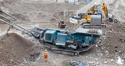 Construction worker on a site, digging with machines Stock Photos