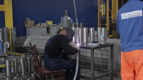 Construction worker at the site welding metal pipes with special blue helmet Vídeo Stock 142877143