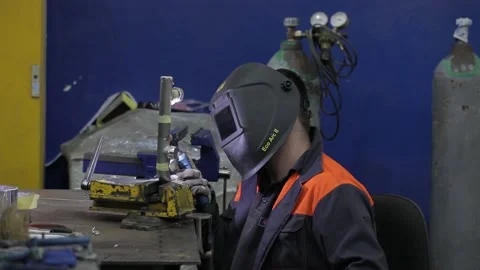 Construction worker at the site welding metal pipes with special blue helmet Stock Footage 142879758