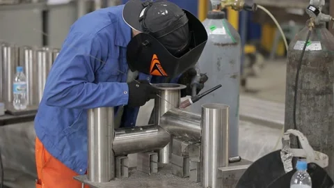 Construction worker at the site welding metal pipes with special blue helmet Stock Footage 142879969