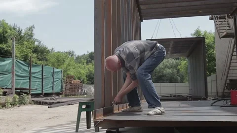 Construction worker at the site welding metal pipes with special blue helmet Stock Footage 142886816
