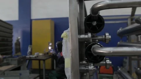 Construction worker at the site welding metal pipes with special blue helmet Stock Footage 142888462
