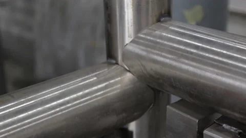 Construction worker at the site welding metal pipes with special blue helmet Stock Footage 142892962