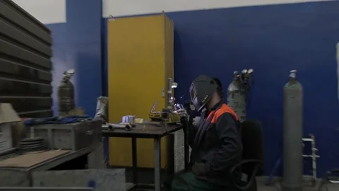 Construction worker at the site welding metal pipes with special blue helmet Stock Footage 142897944