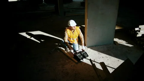 Construction worker sits near the wall and open toolbox at construction site Video stock 258672968