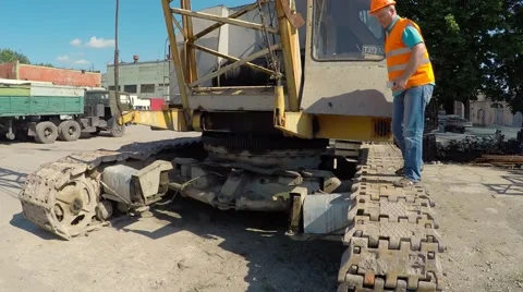 Construction worker sitting on large crawler cranes and eats a burger. 库存影片 52250963