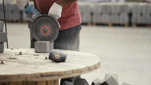 A construction worker skillfully cutting concrete blocks using a handheld Stock Footage 312633744