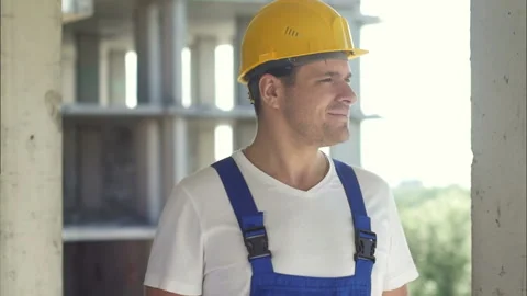 Construction worker smiling and looking away on a sky background Stock Footage 122395445