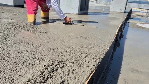 Construction worker smoothing fresh concrete with hand trowel 動画素材 340157336