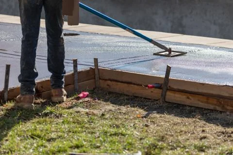 Construction Worker Smoothing Wet Cement With Long Handled Edger Tool Stock Photos