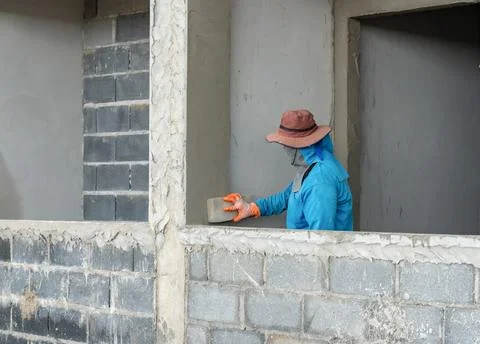 Construction worker smoothing a wet concrete plaster wall using a sponge fl.. Stock Photos