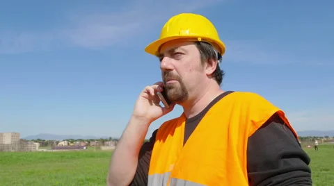 Construction worker speaks with his boss by phone Stock Footage 63092078