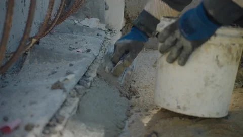 Construction worker spreading cement with trowel, leveling foundation edge with Video stock 306396796