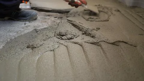 Construction worker spreading concrete mix with trowel Stock Photos