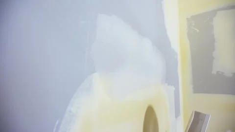 Construction worker spreading joint compound on drywall wall corner using a Stock Footage 320263243