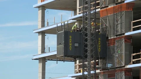 Construction worker squatting going down the elevator Stock Footage 80795238