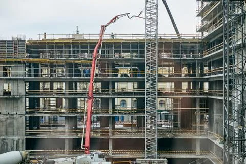 Construction worker standing on top of an unfinished building with finished Stock Photos
