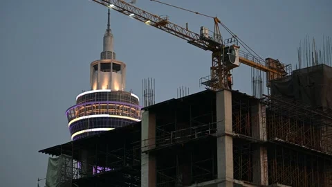 Construction worker stands beside Samut Prakan tower crane Vidéo 339876949