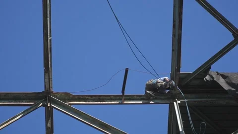 Construction Worker on Steel Framework Against Clear Blue Sky Stock Footage 339123143