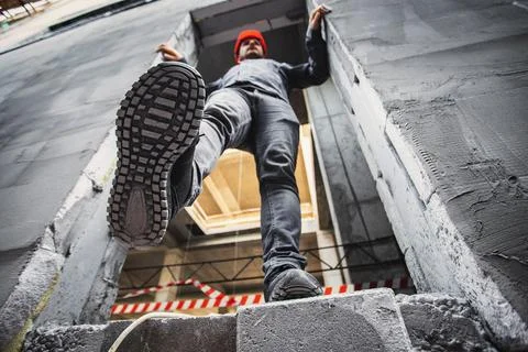 A construction worker steps into an unguarded, dangerous opening at a Stock Photos