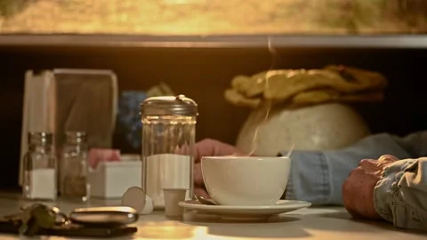A construction worker stirring his steaming hot cup of coffee in a diner Stock Footage 237177029