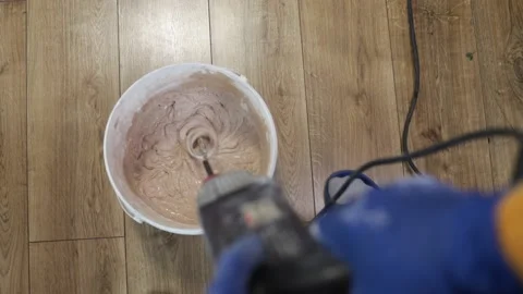 Construction worker stirs mortar. Bricklayer mixing cement in bucket. Stock-Footage 216040658
