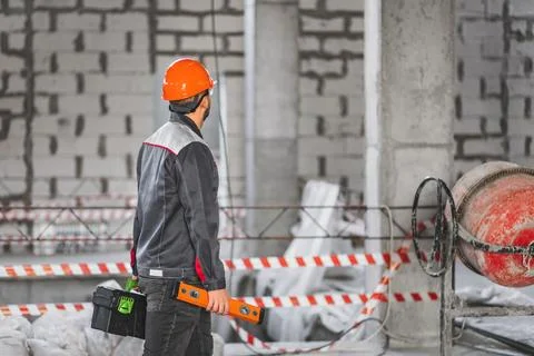 Construction worker with a suitcase with tools and level tool, in overalls Stock Photos