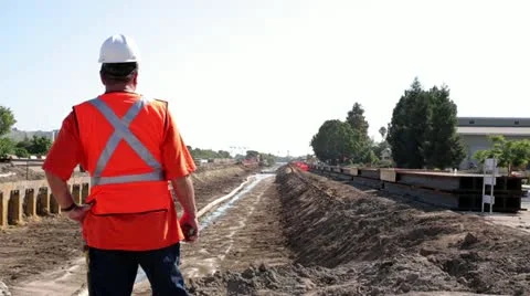 Construction worker surveying irrigation ditch Stock Footage 11811540