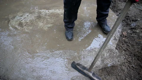 Construction worker sweeping and cleaning concrete foundation Stock Footage 158974426