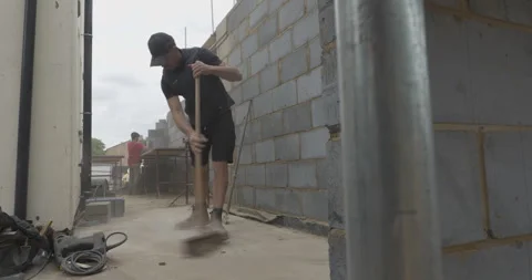 Construction worker sweeping rubble on a building site Stock Footage 246381684
