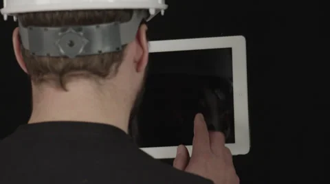 Construction worker swipes white tablet with finger (Over-the-shoulder) 库存影片 32264055