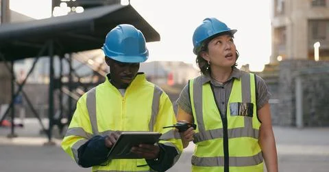 Construction worker, tablet and talking about engineering, contractor and Stock Photos