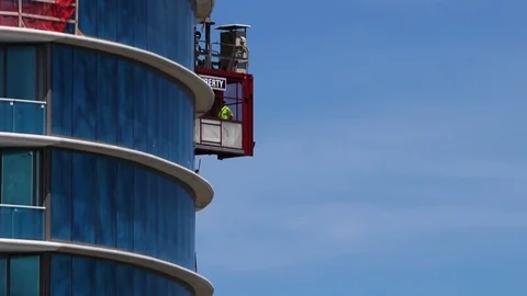 A construction worker takes a construction elevator up a skyscraper. Stock Footage 95947282