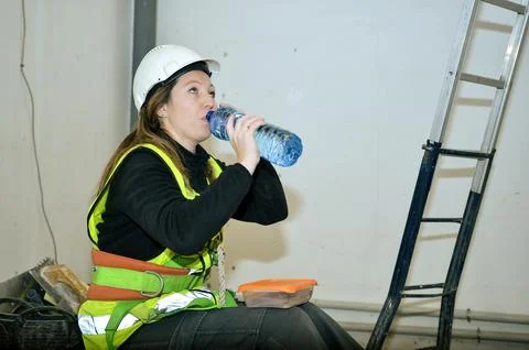 Construction worker taking break and drinking water on site Stock Photos