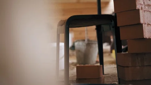 A construction worker is taking a bucket of cement solution and standing on a Stock Footage 90092784