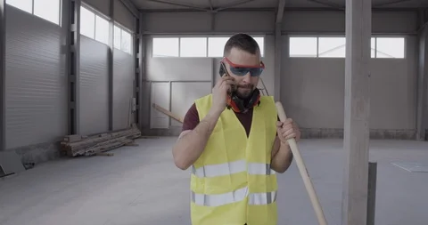 A construction worker, talking on the phone and walking angry and stirred. Stock Footage 127202526