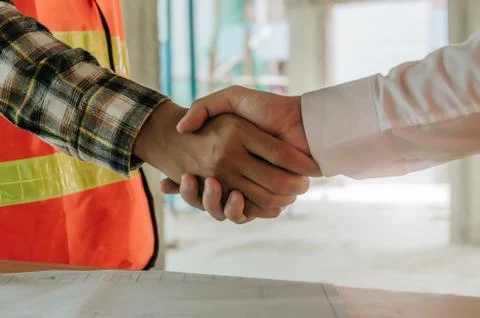 Construction worker team contractor hand shake after finishing up a business  Stock Photos