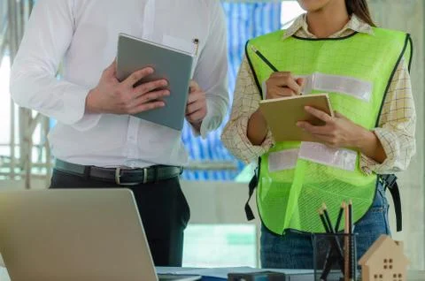 Construction worker team writing and planning about building plan with tablet Stock Photos