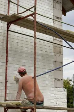 Construction worker thermally insulating house facade Stock Photos