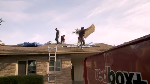 Construction Worker Throwing Roof Shingles into Dumpster Stock Footage 329089113