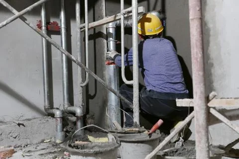 Construction Worker in Tight Corner Under Scaffolding Stock Photos