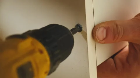 Construction worker tightens screw to fix cabinet panel in place Video stock 304403112