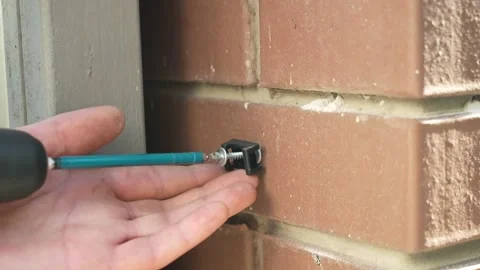 Construction worker tightens the screws using an electric drill Stock Footage 258645995