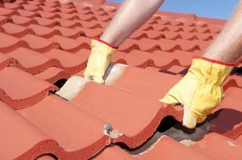 Construction worker tile roofing repairs Stock Photos
